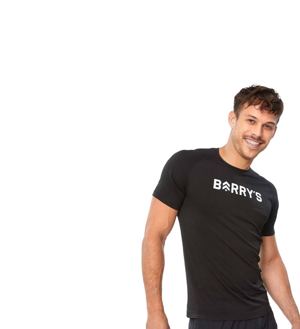 Barry's instructor standing confidently, wearing a black top against a white background, ready for the next workout challenge.