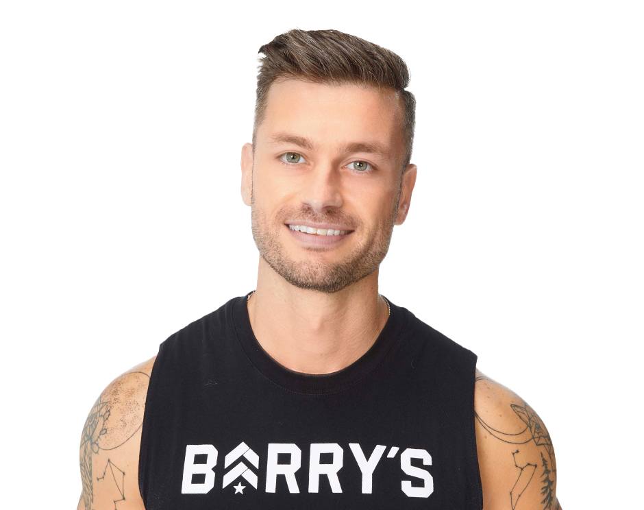 Barry's instructor standing confidently, wearing a black tank top against a white background, ready for the next workout challenge.