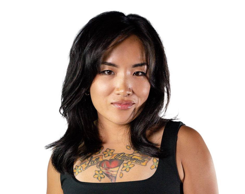 Barry’s instructor wearing a black top standing confidently smiling against a white background