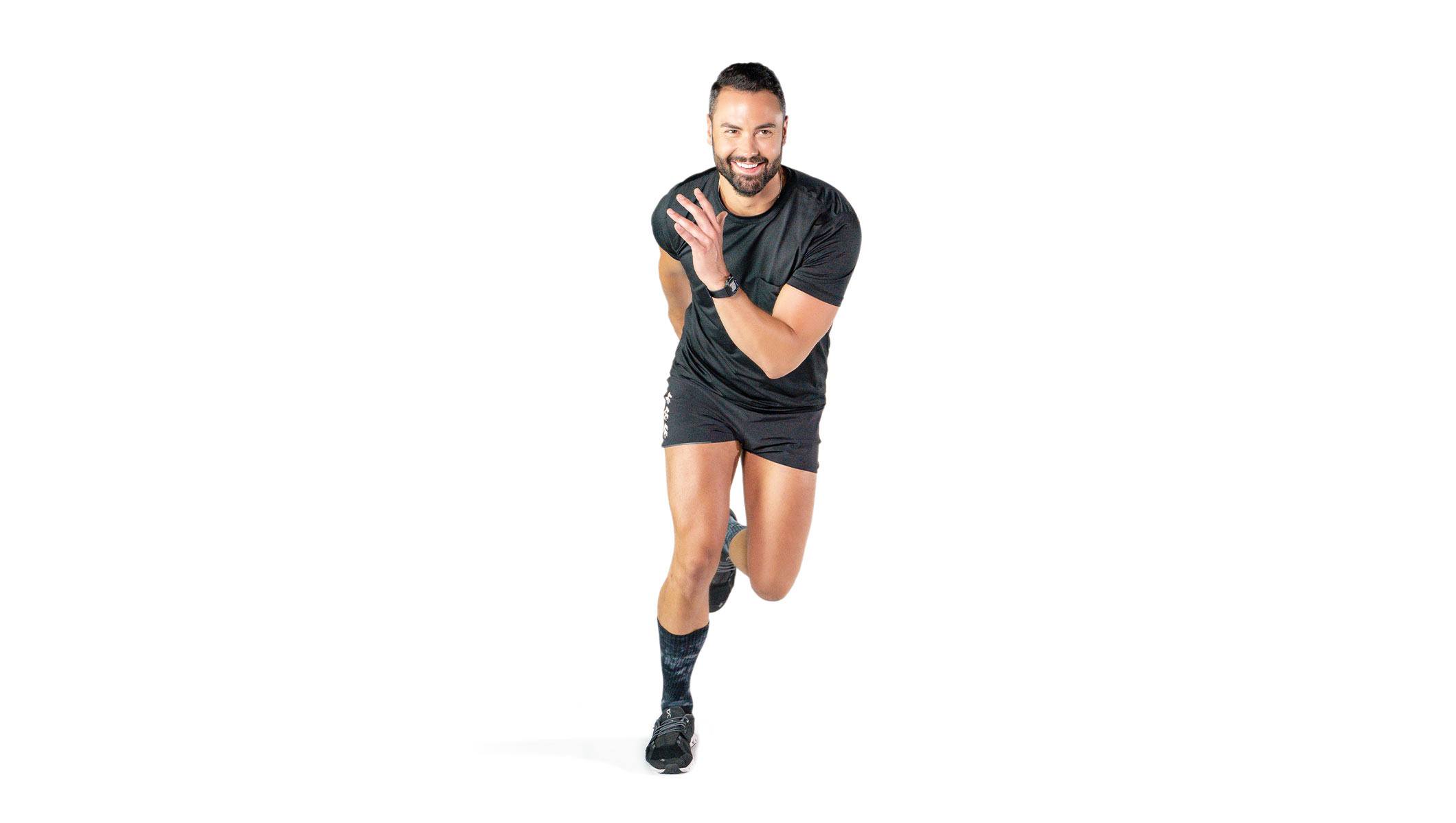 Barry’s instructor wearing a black top in a running position smiling against a white background