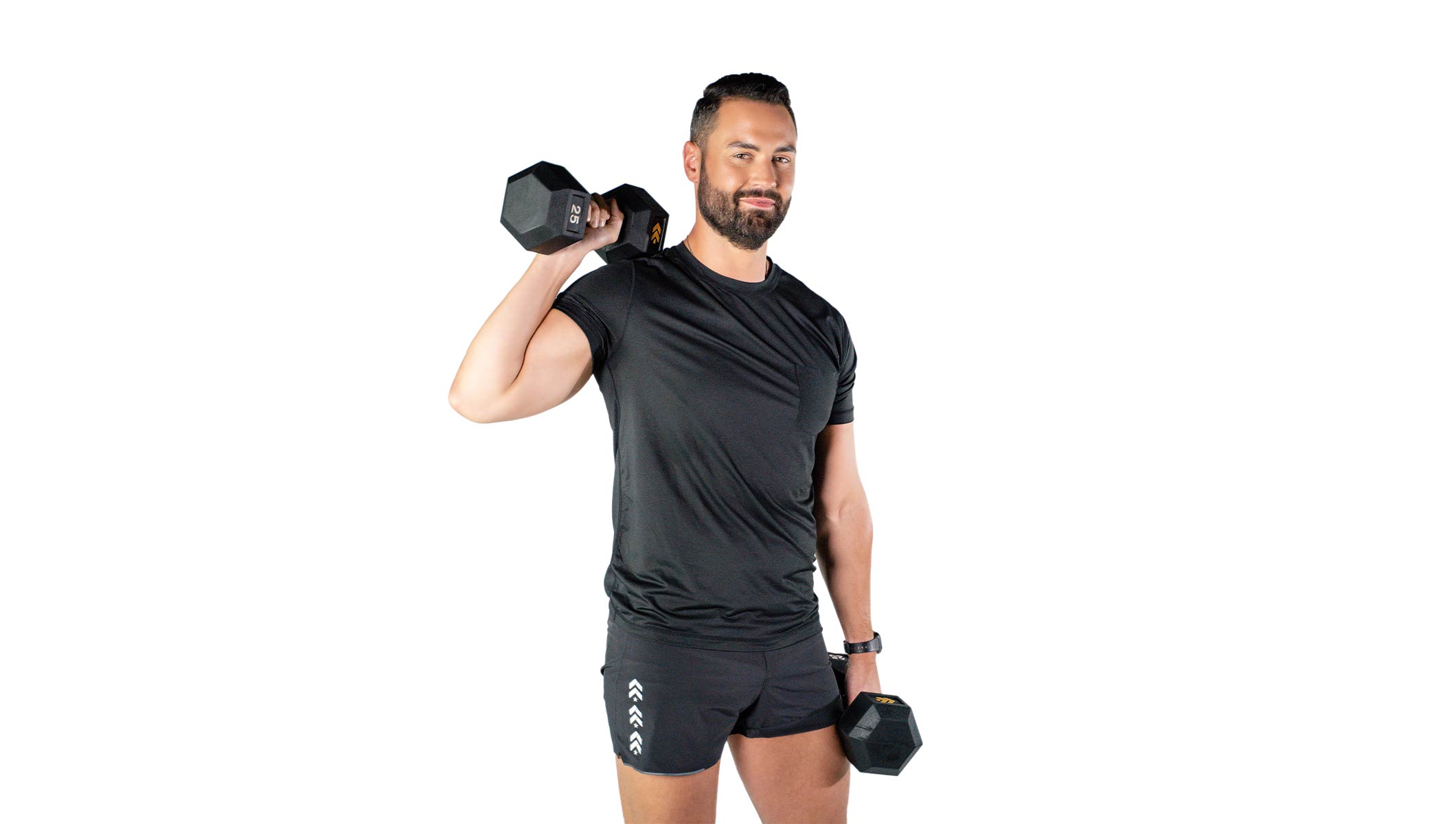 Barry’s instructor wearing a black top standing confidently smiling against a white background with weights in hand
