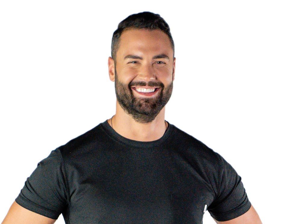 Barry’s instructor wearing a black top standing confidently smiling against a white background