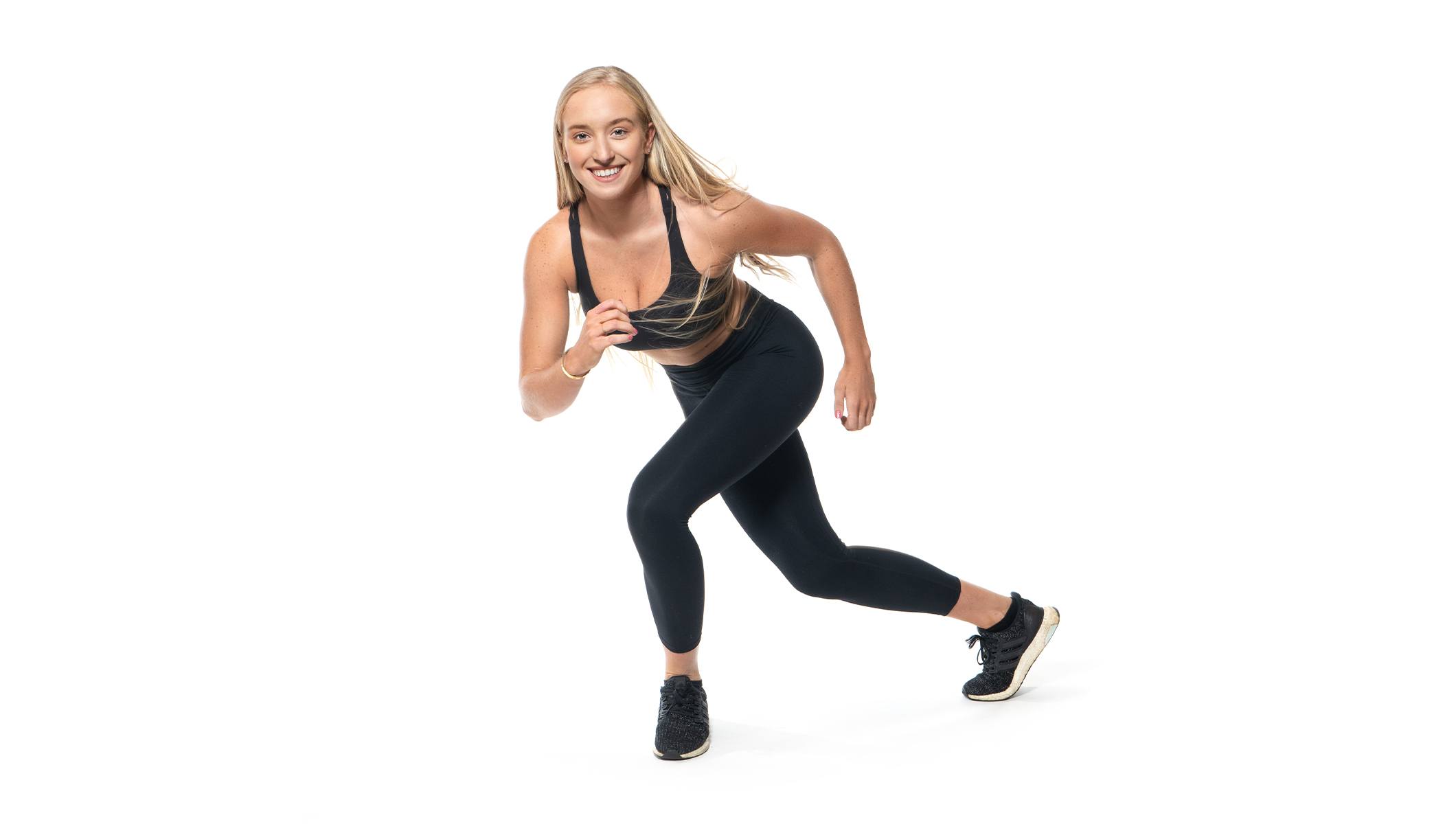 Barry's instructor in a side lunge wearing a black top against a white background.