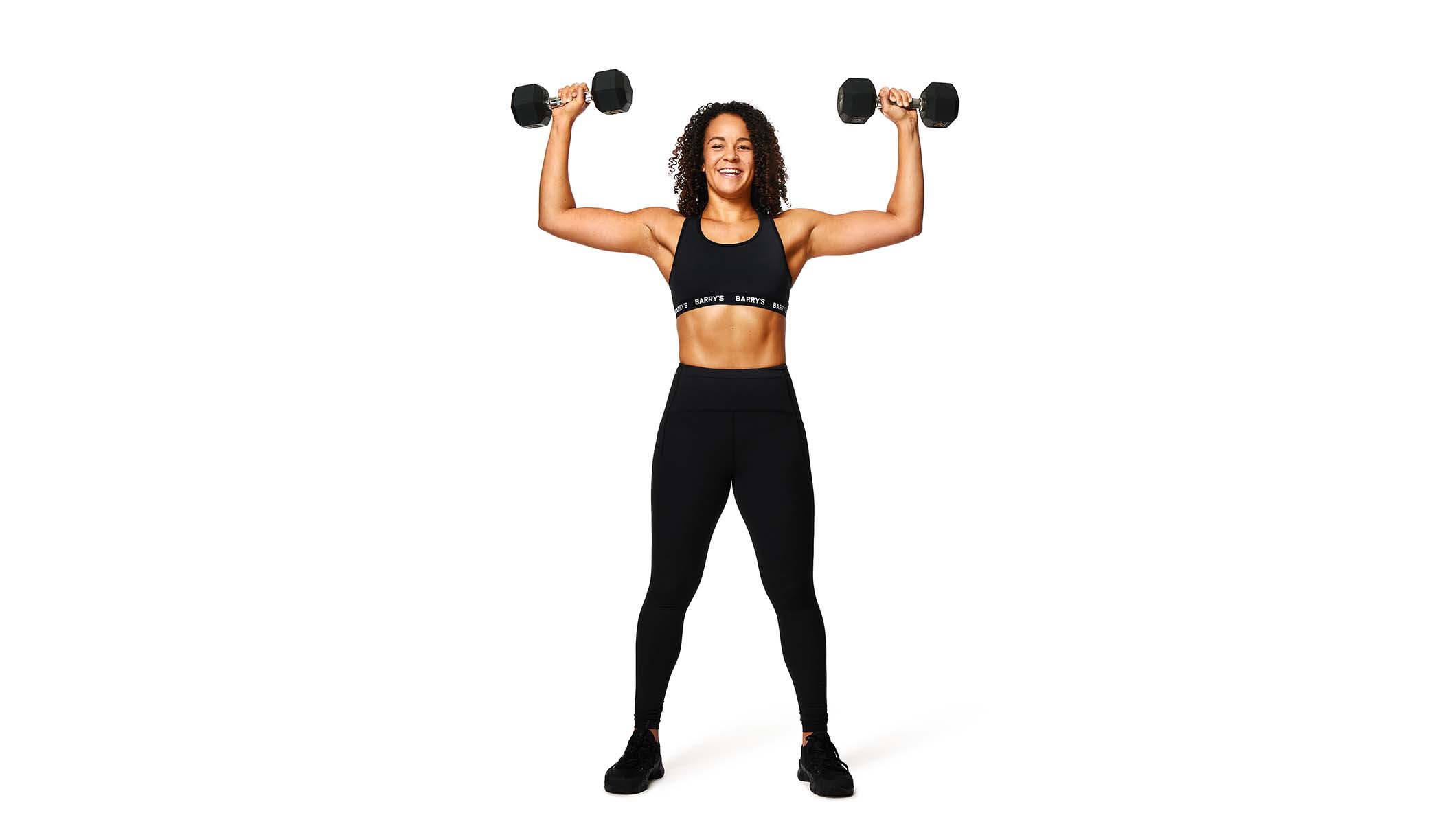 Barry's instructor lifting weights wearing a black top against a white background.