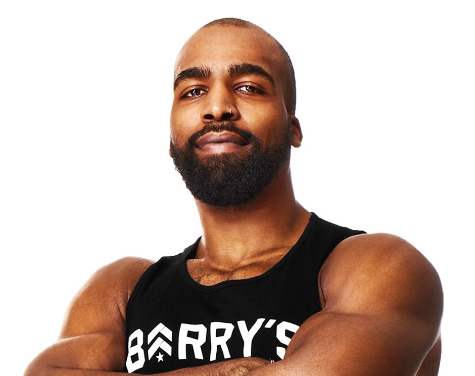Barry’s instructor wearing a black top standing confidently smiling against a white background
