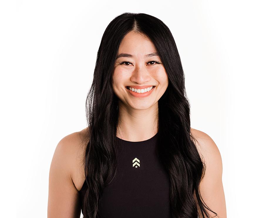 Barry’s instructor wearing a black top standing confidently smiling against a white background