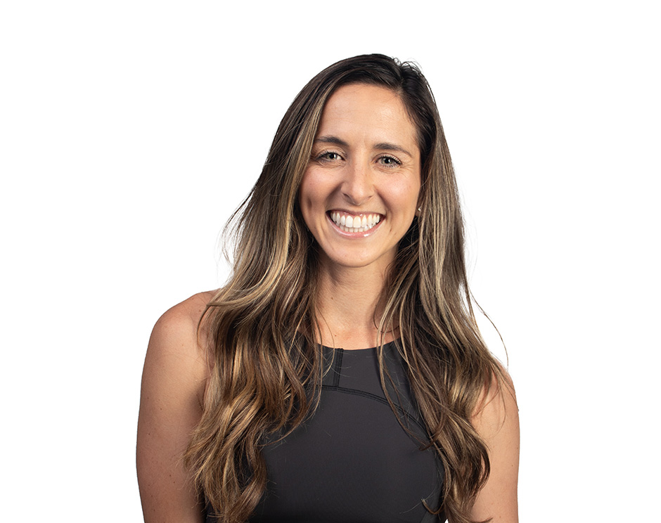 Barry’s instructor wearing a black top standing confidently smiling against a white background