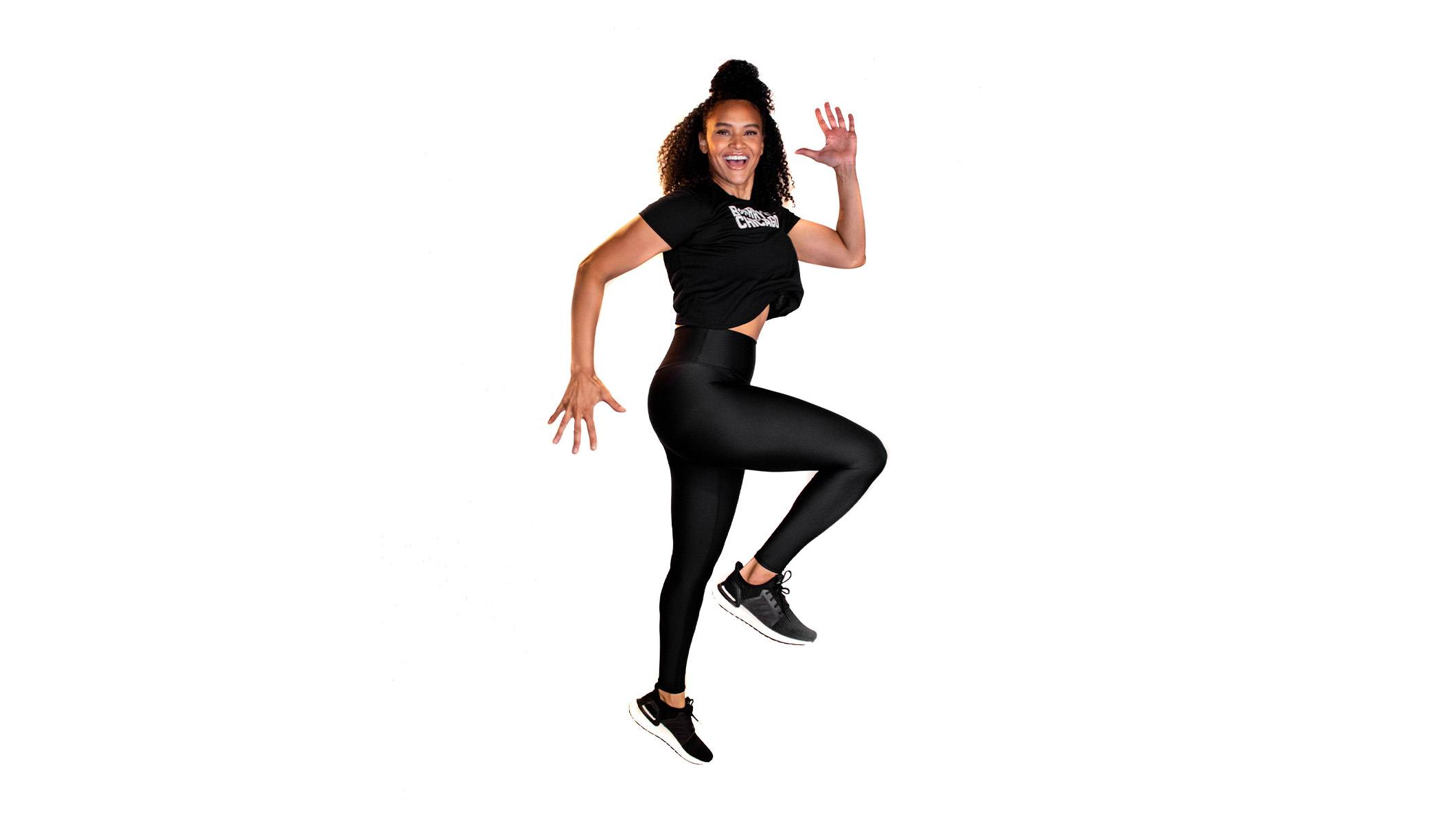 Barry's instructor in a running jump wearing a black top against a white background.