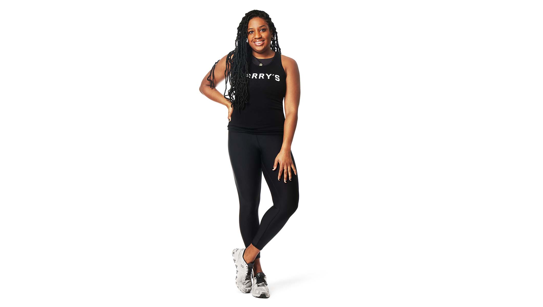 Barry’s instructor wearing a black top standing confidently smiling against a white background