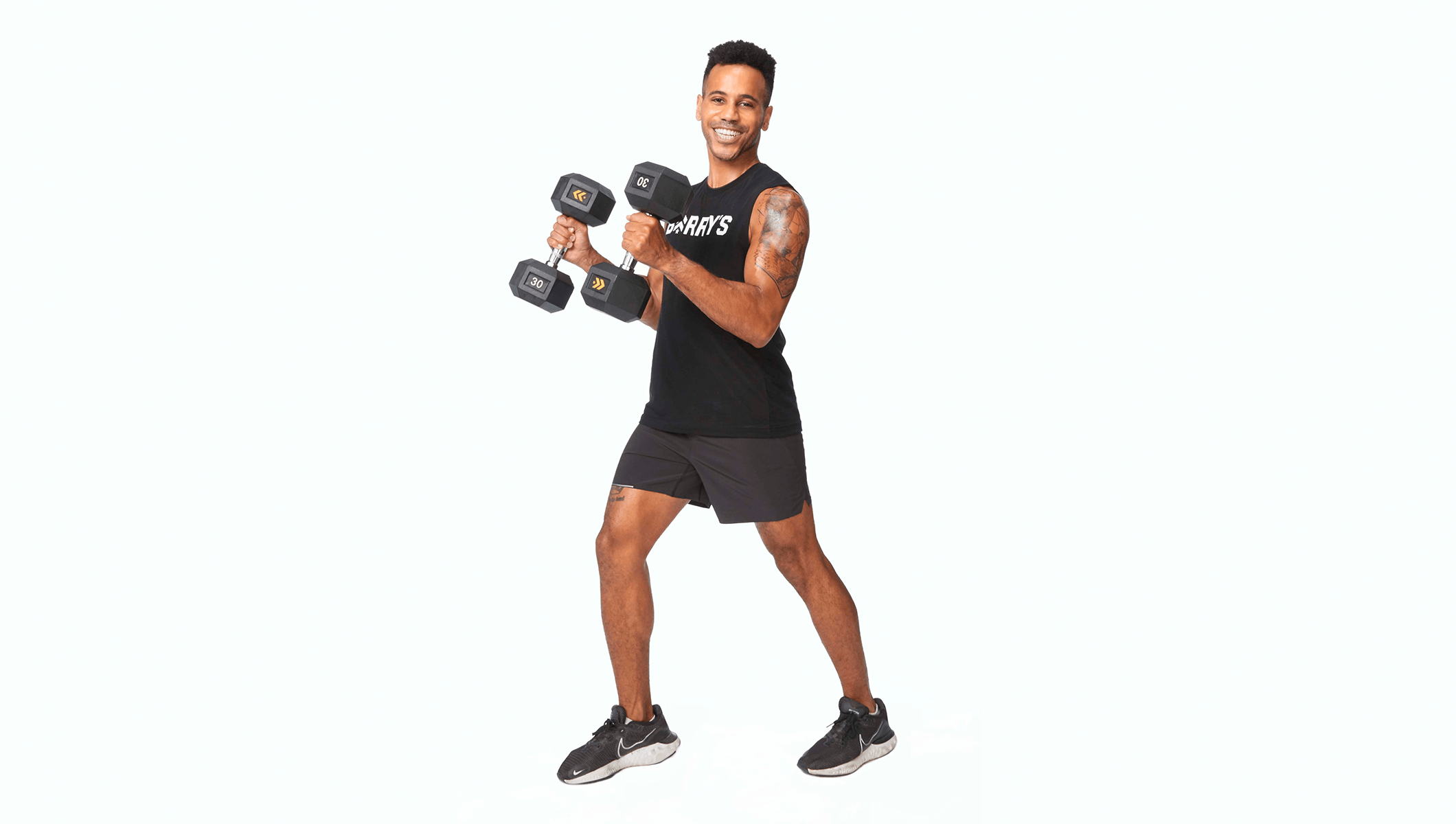 Barry's instructor holding weights wearing a black top against a white background.