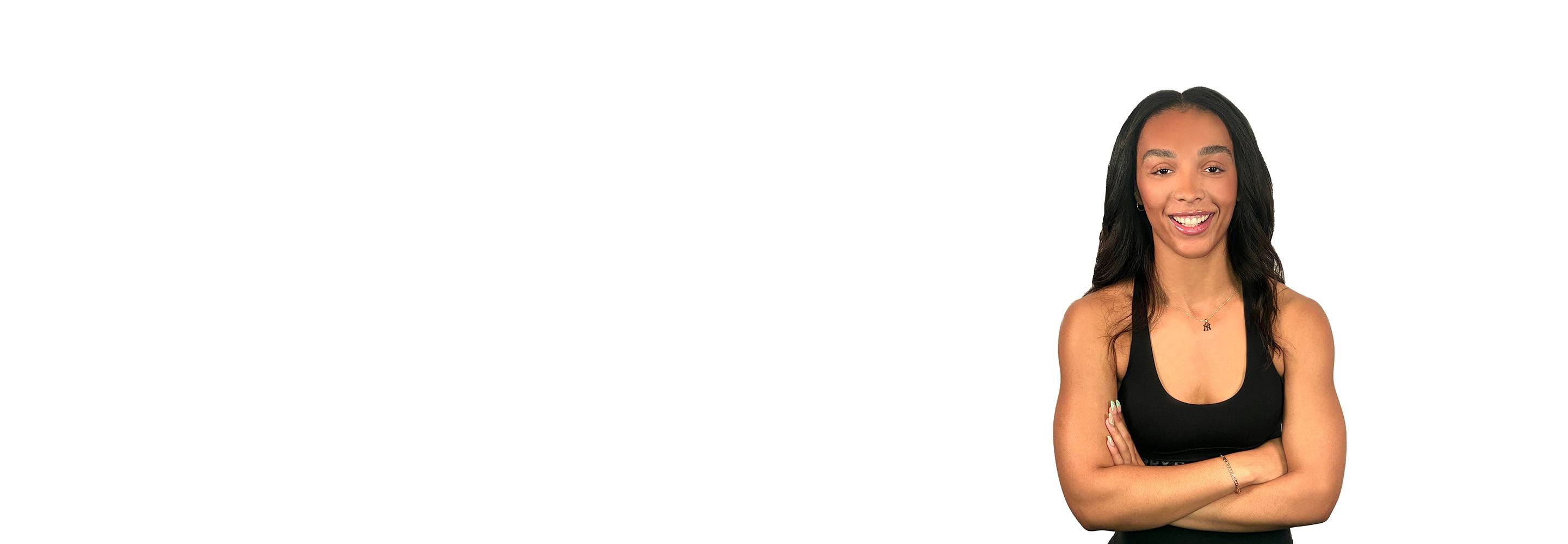 Barry’s instructor wearing a black top standing confidently smiling against a white background