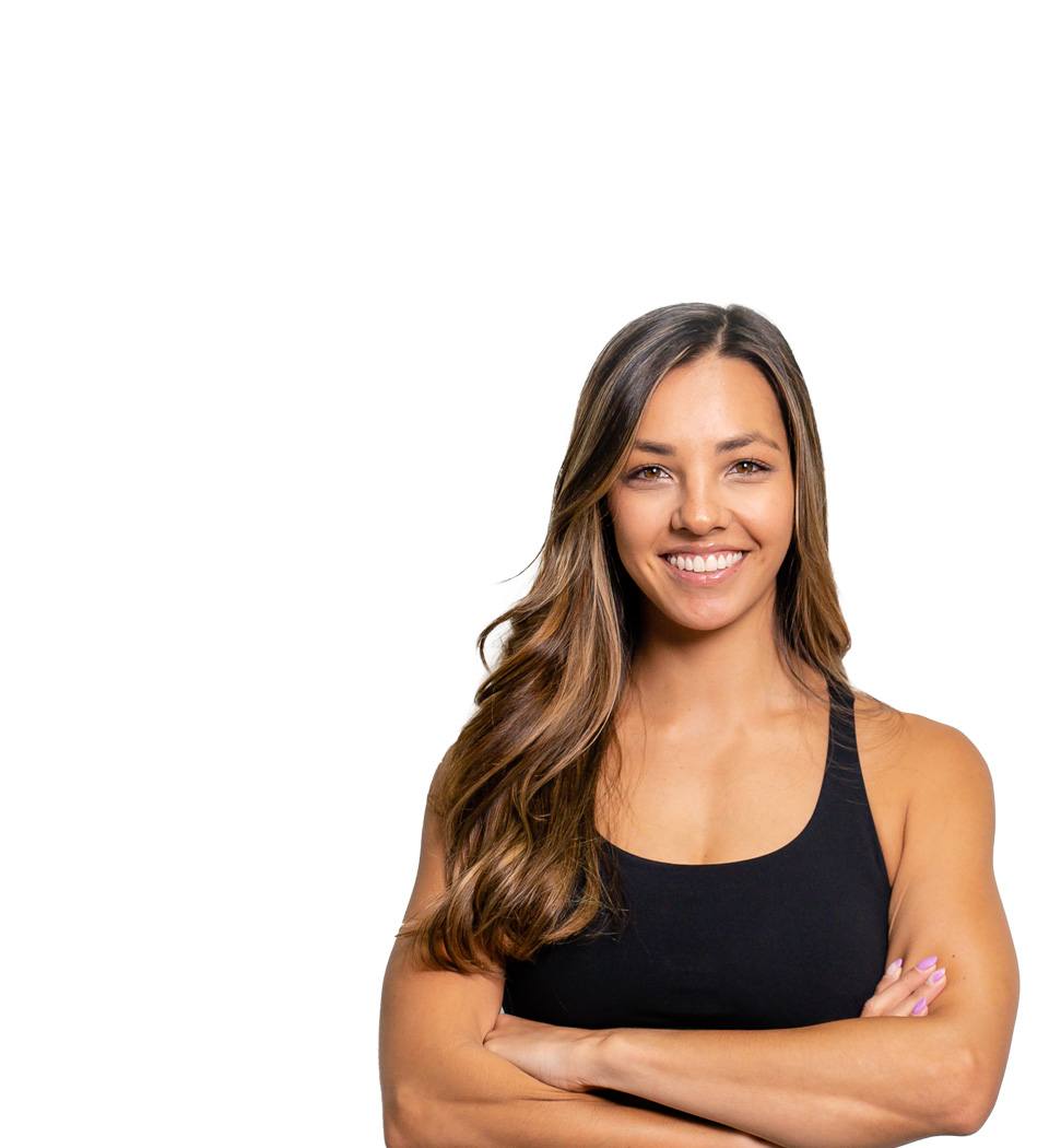 Barry’s instructor wearing a black top standing confidently smiling against a white background