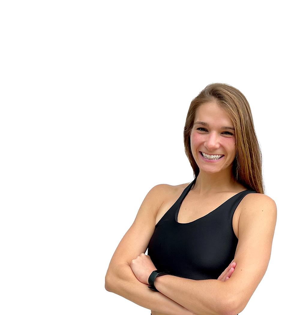 Barry’s instructor wearing a black top standing confidently smiling against a white background