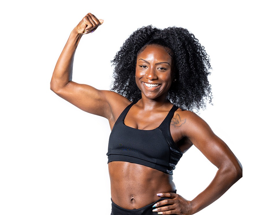 Barry’s instructor wearing a black top standing confidently smiling against a white background