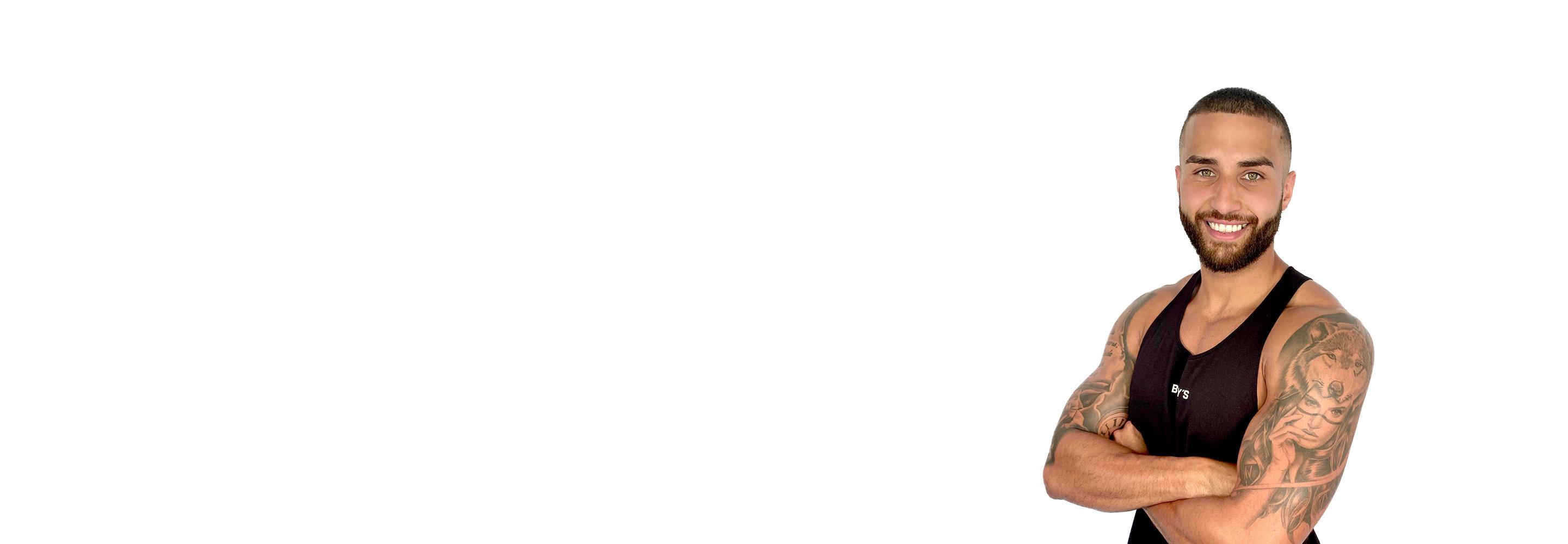 Barry’s instructor wearing a black top standing confidently smiling against a white background