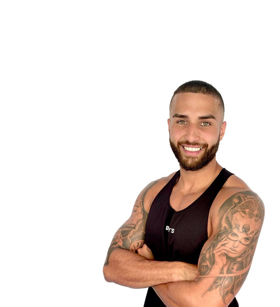 Barry’s instructor wearing a black top standing confidently smiling against a white background