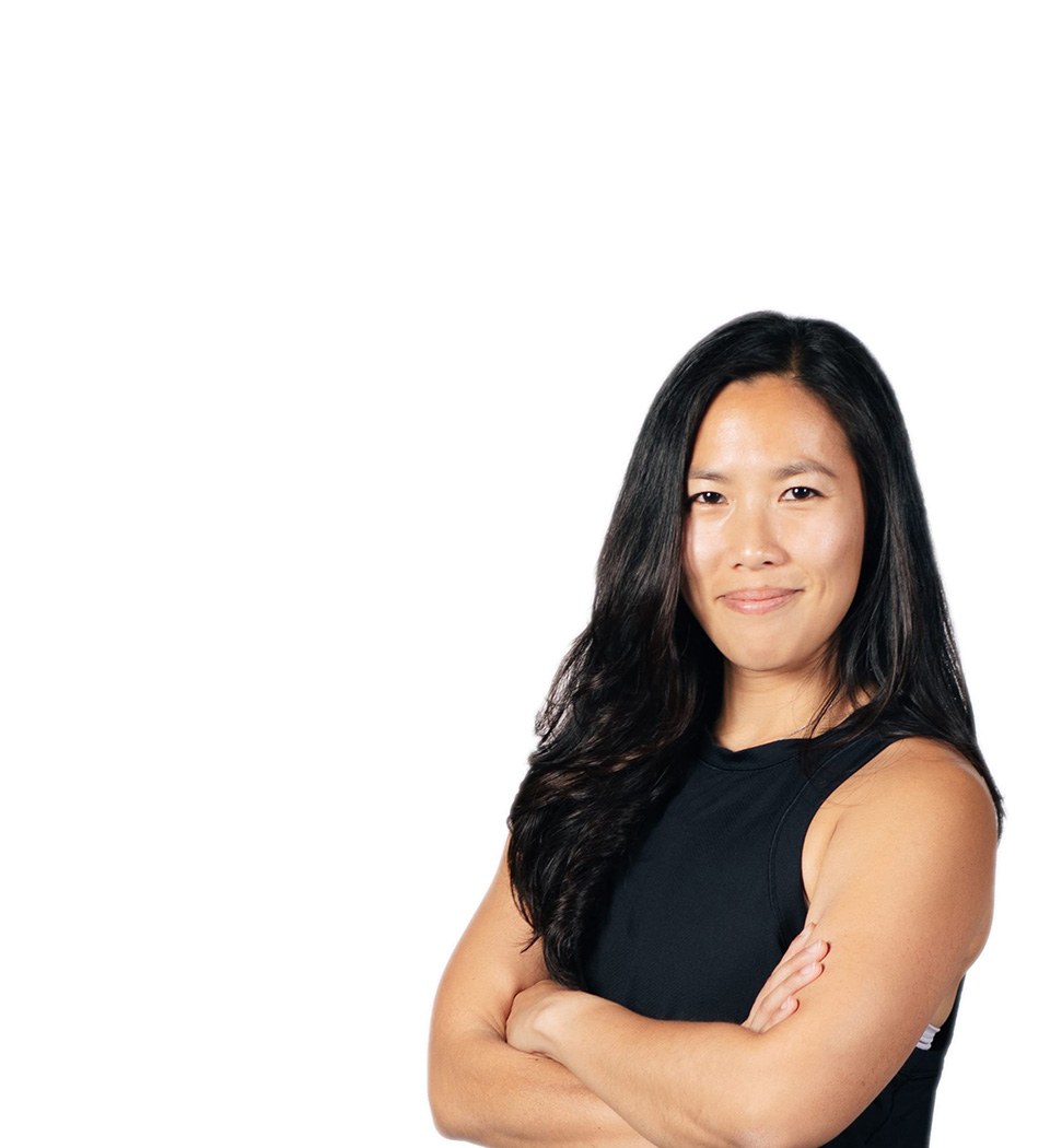 Barry's instructor standing confidently with arms crossed in front, wearing a black tank top against a white background, ready for the next workout challenge.