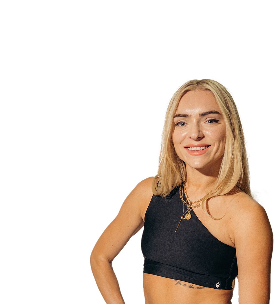 Barry’s instructor wearing a black top standing confidently smiling against a white background