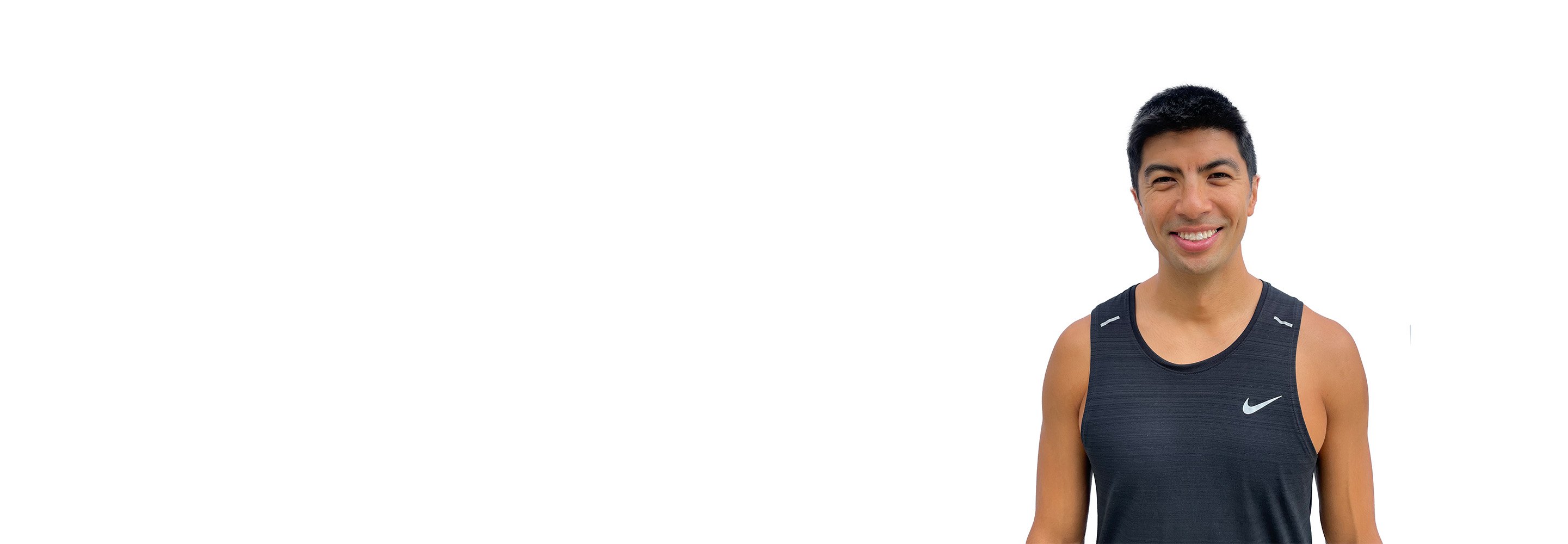 Barry’s instructor wearing a black top standing confidently smiling against a white background