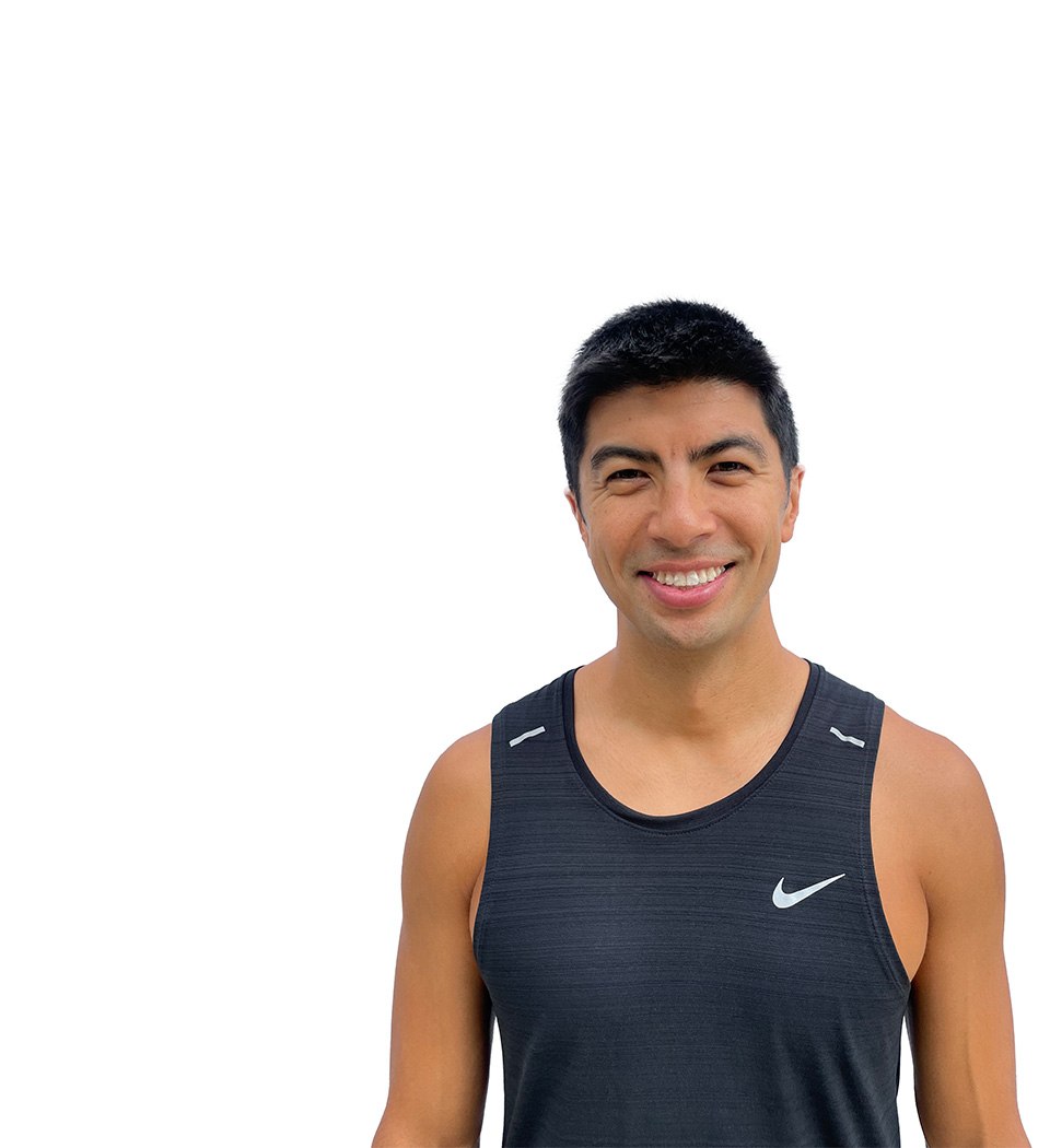 Barry’s instructor wearing a black top standing confidently smiling against a white background