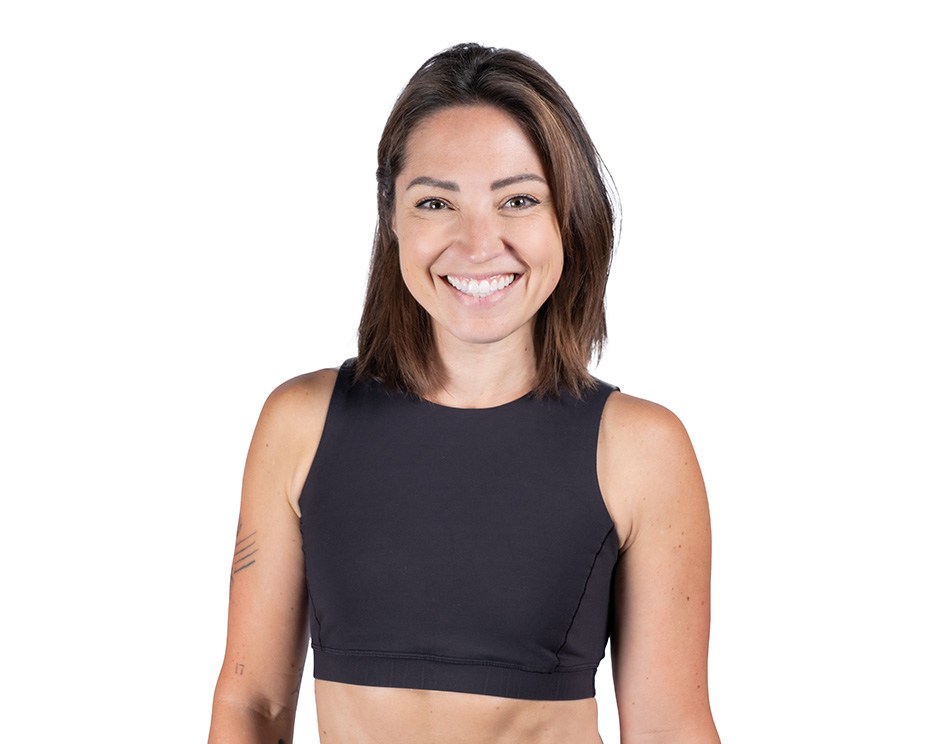 Barry’s instructor wearing a black top standing confidently smiling against a white background