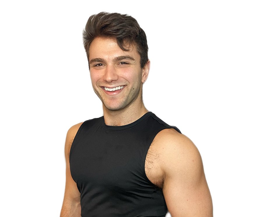Barry’s instructor wearing a black top standing confidently smiling against a white background