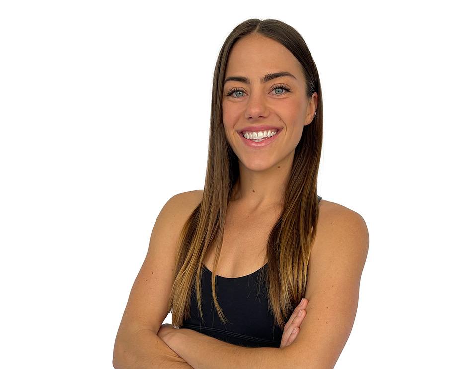 Barry's instructor standing confidently with arms crossed wearing a black top against a white background.