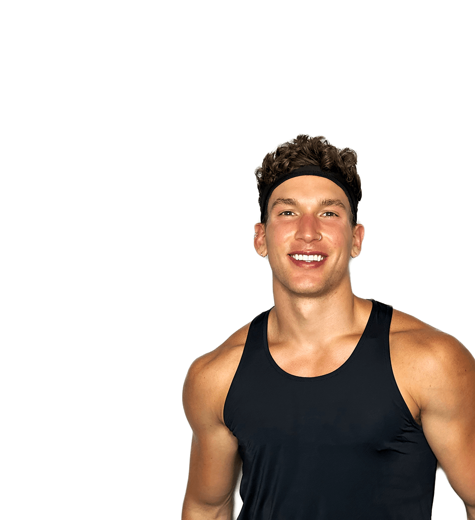 Barry’s instructor wearing a black top standing confidently smiling against a white background