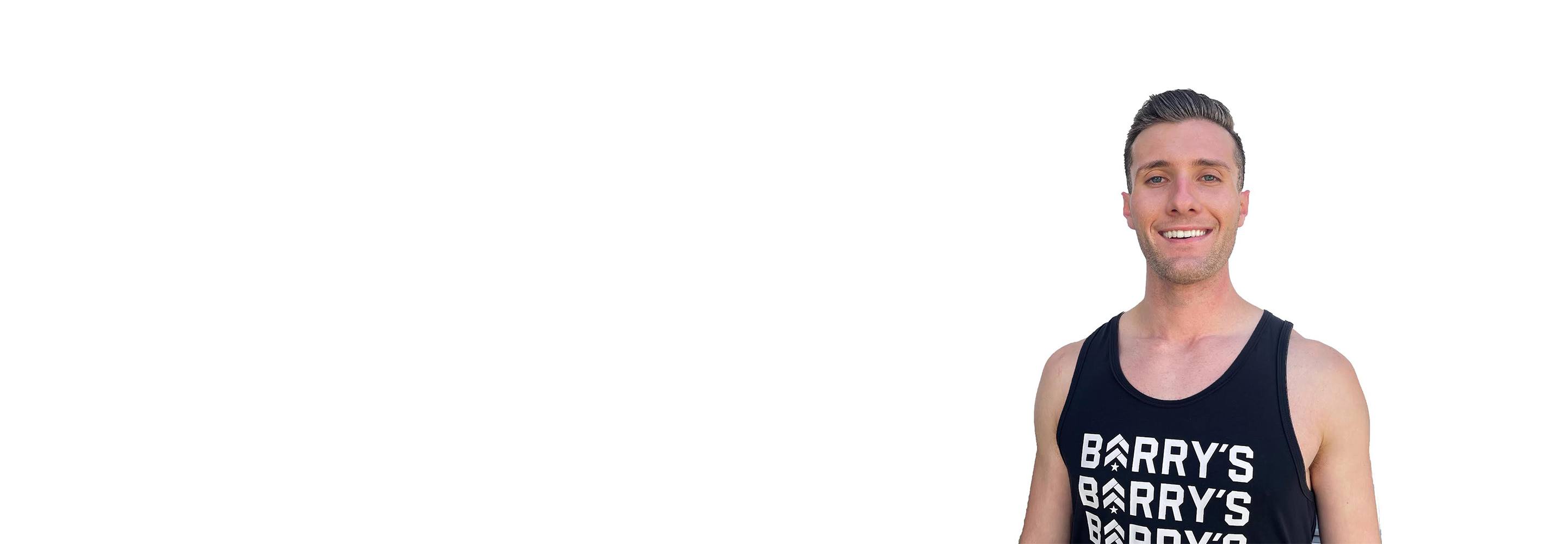 Barry's instructor standing confidently wearing a black tank top against a white background.
