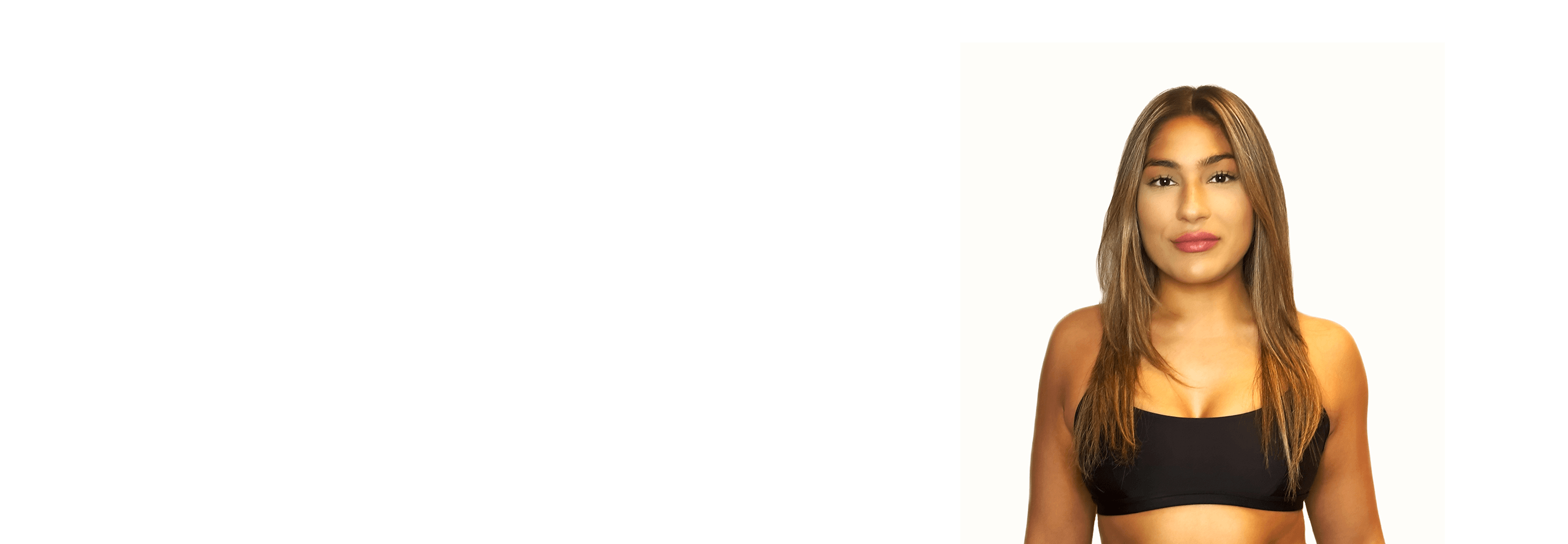 Barry’s instructor wearing a black top standing confidently smiling against a white background