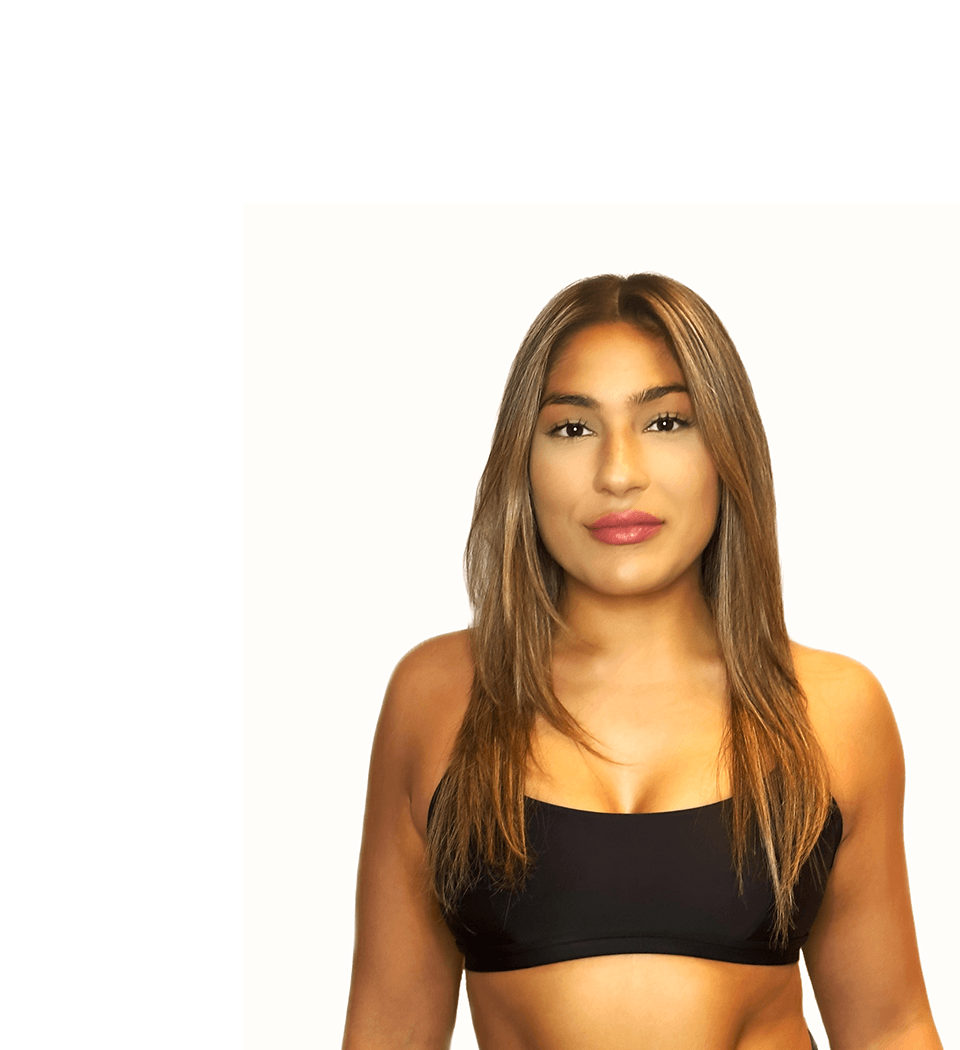 Barry’s instructor wearing a black top standing confidently smiling against a white background