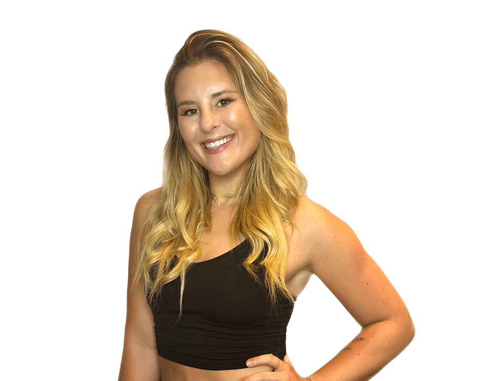 Barry’s instructor wearing a black top standing confidently smiling against a white background