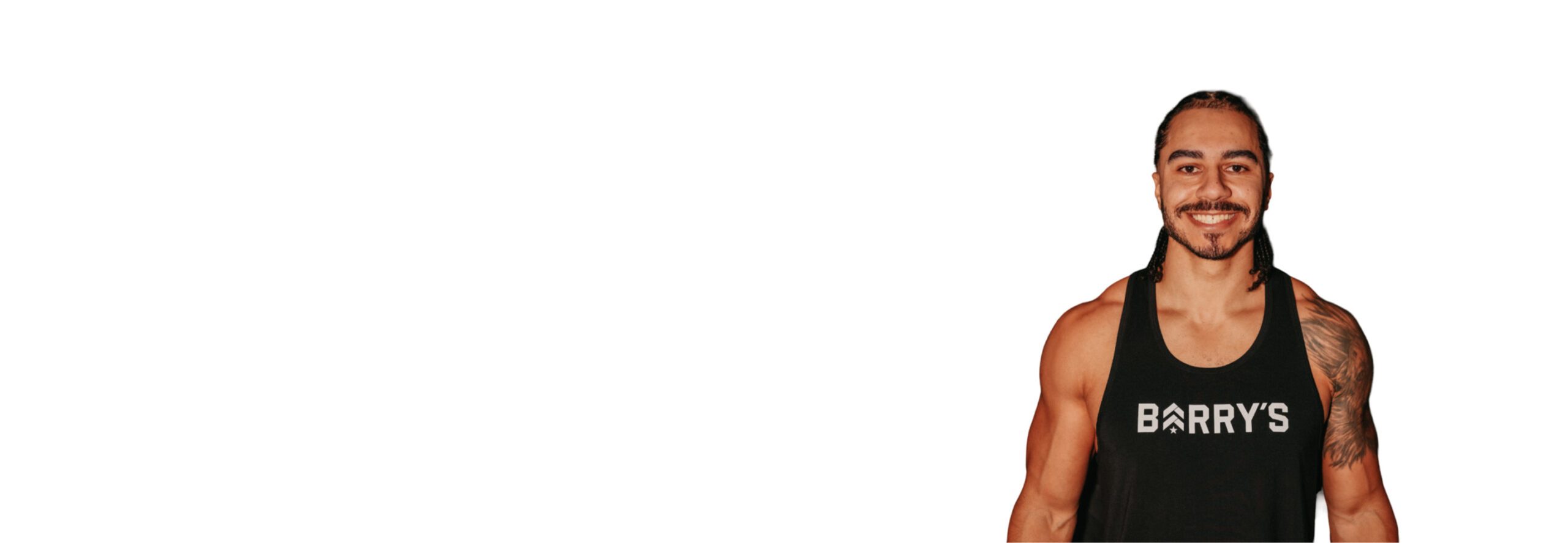 Barry’s instructor wearing a black top standing confidently smiling against a white background