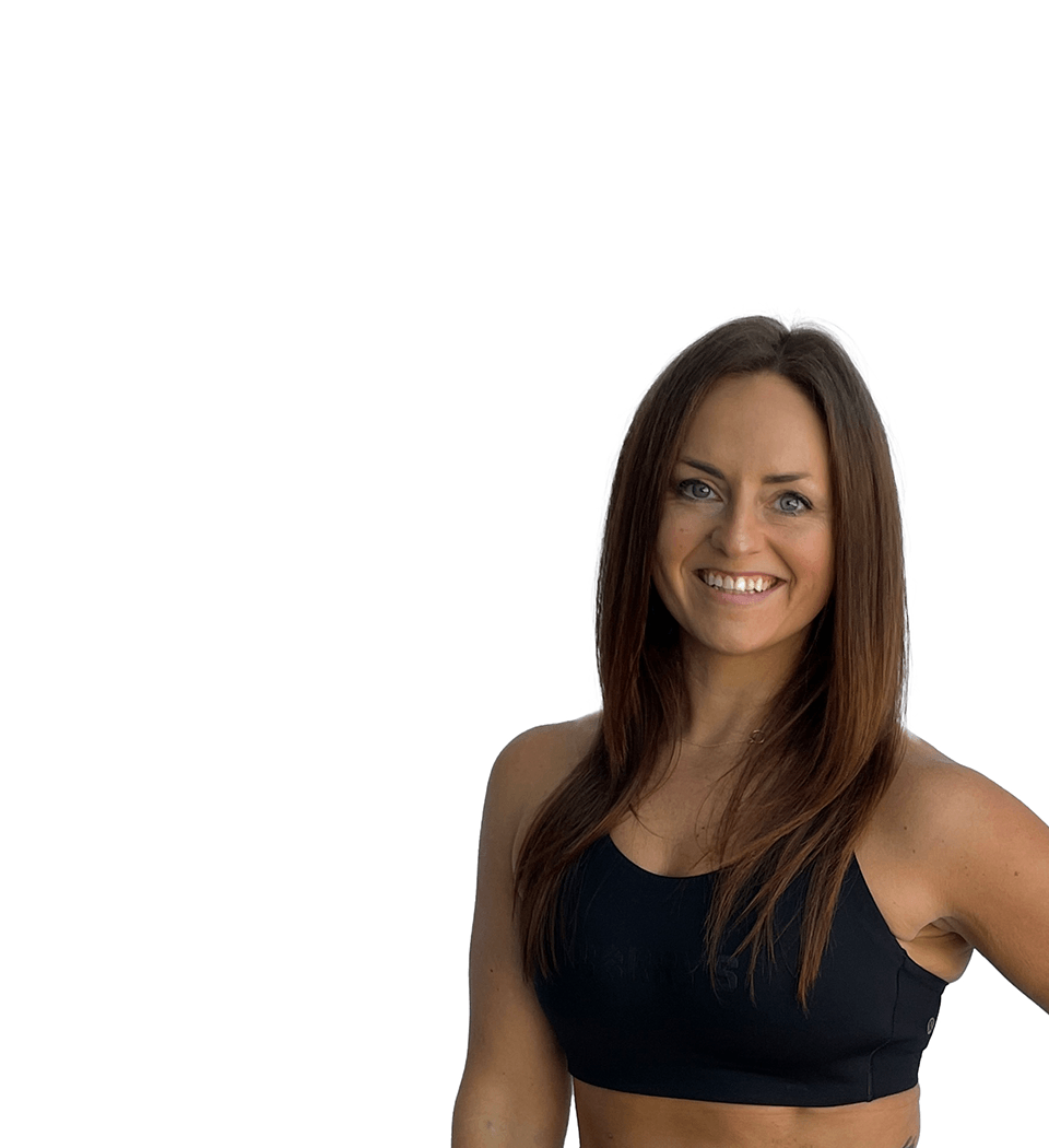 Barry’s instructor wearing a black top standing confidently smiling against a white background