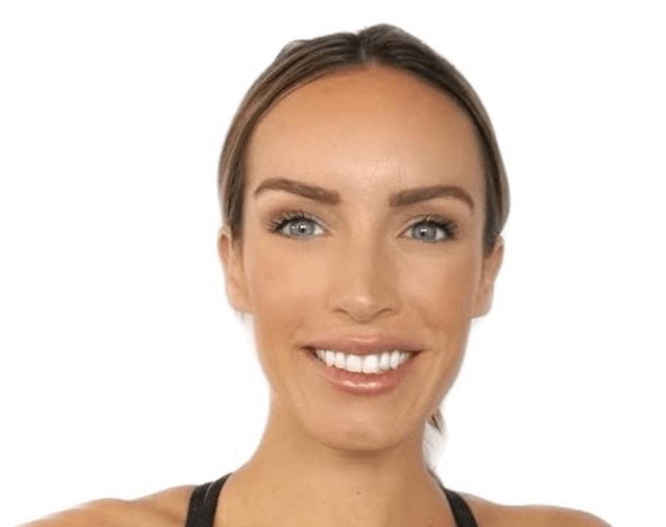 Barry’s instructor wearing a black top standing confidently smiling against a white background