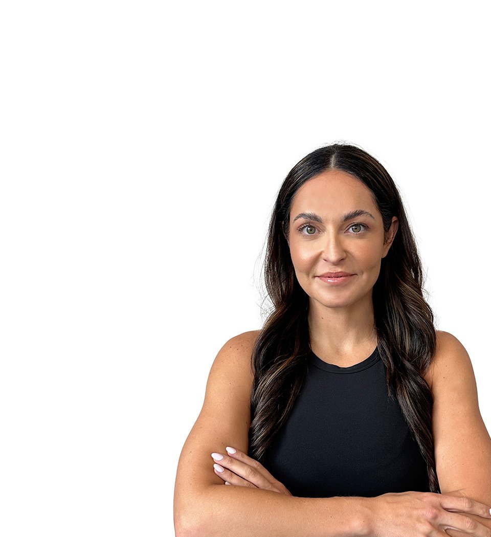 Barry’s instructor wearing a black top standing confidently smiling against a white background