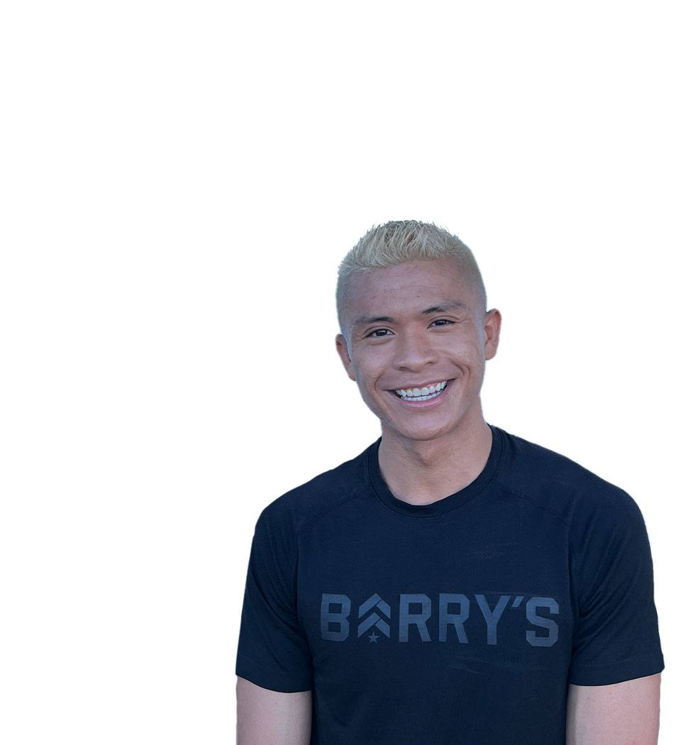 Barry's instructor standing confidently wearing a black top against a white background, ready for the next workout challenge.