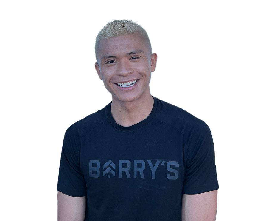 Barry's instructor standing confidently wearing a black top against a white background, ready for the next workout challenge.