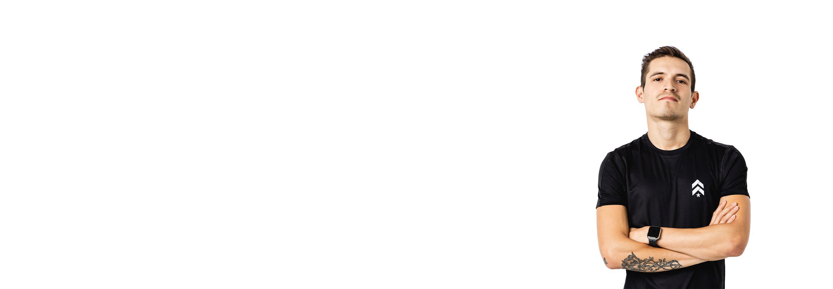 Barry’s instructor wearing a black top standing confidently smiling against a white background