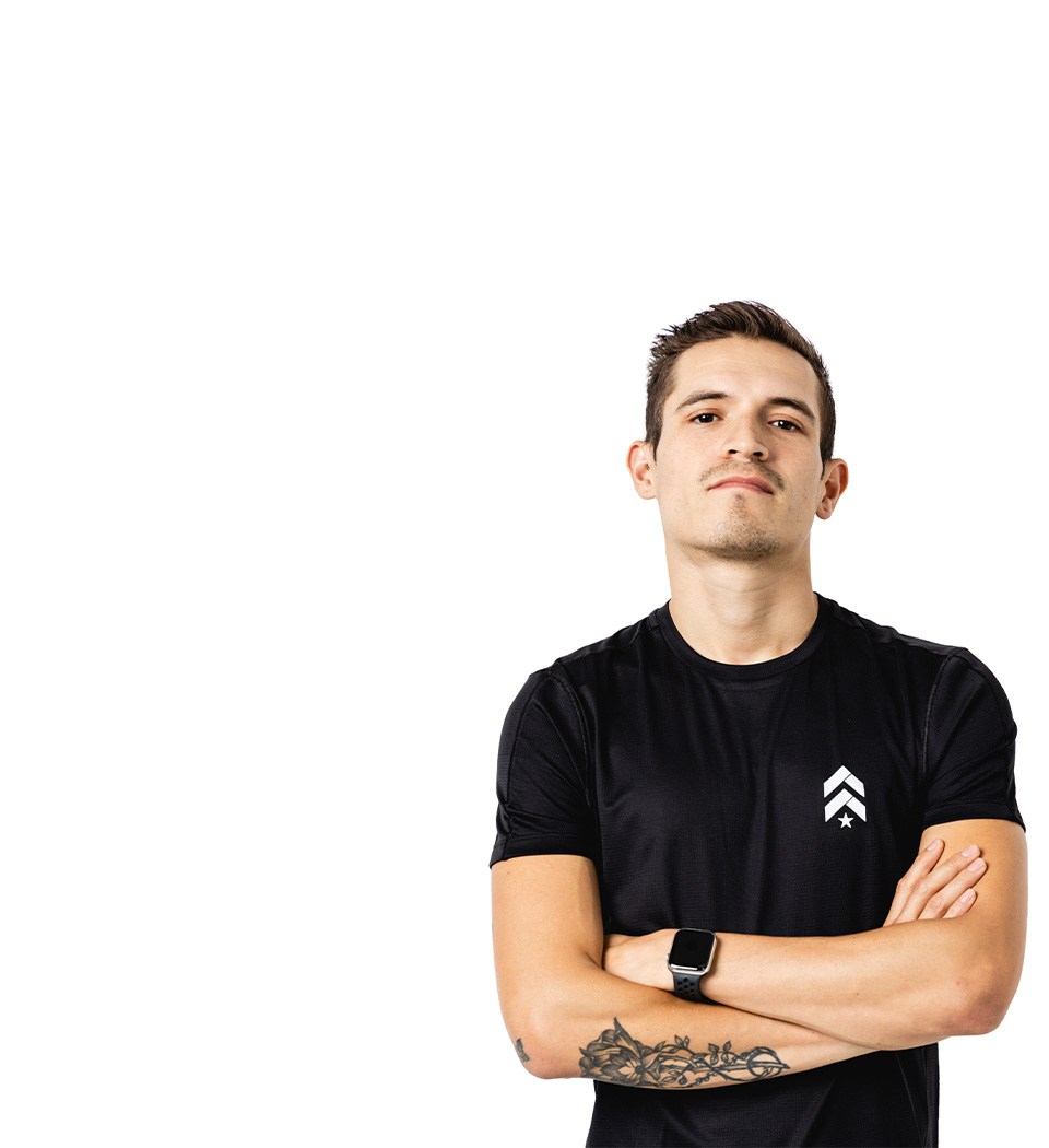 Barry’s instructor wearing a black top standing confidently smiling against a white background