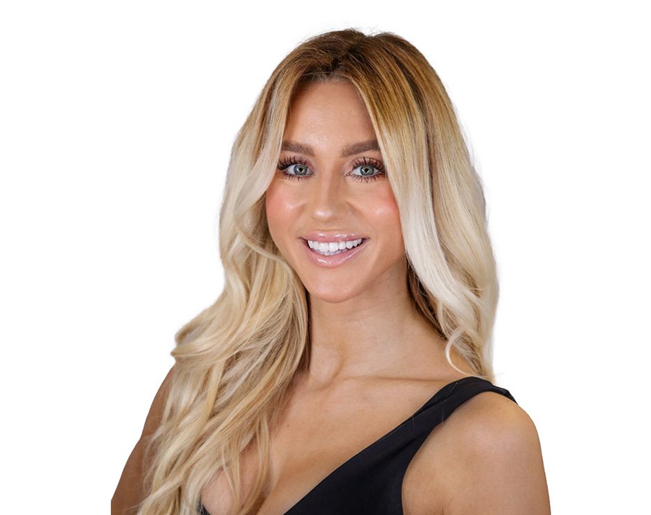 Barry’s instructor wearing a black top standing confidently smiling against a white background