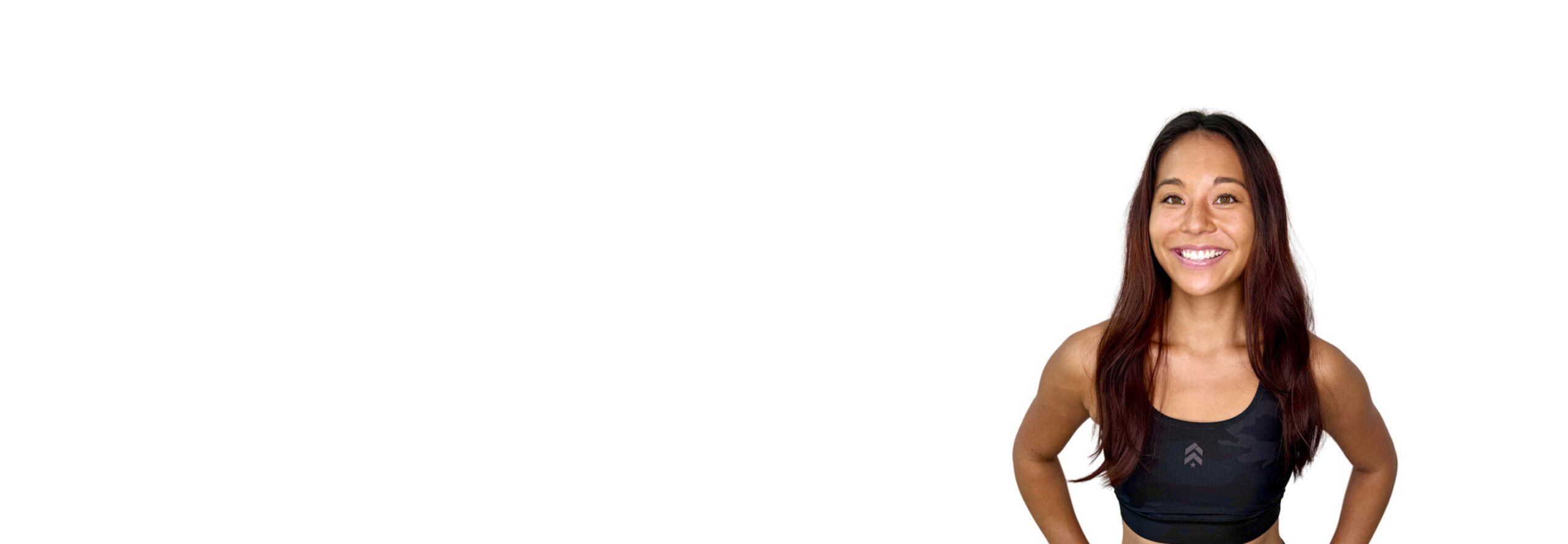 Barry’s instructor wearing a black top standing confidently smiling against a white background