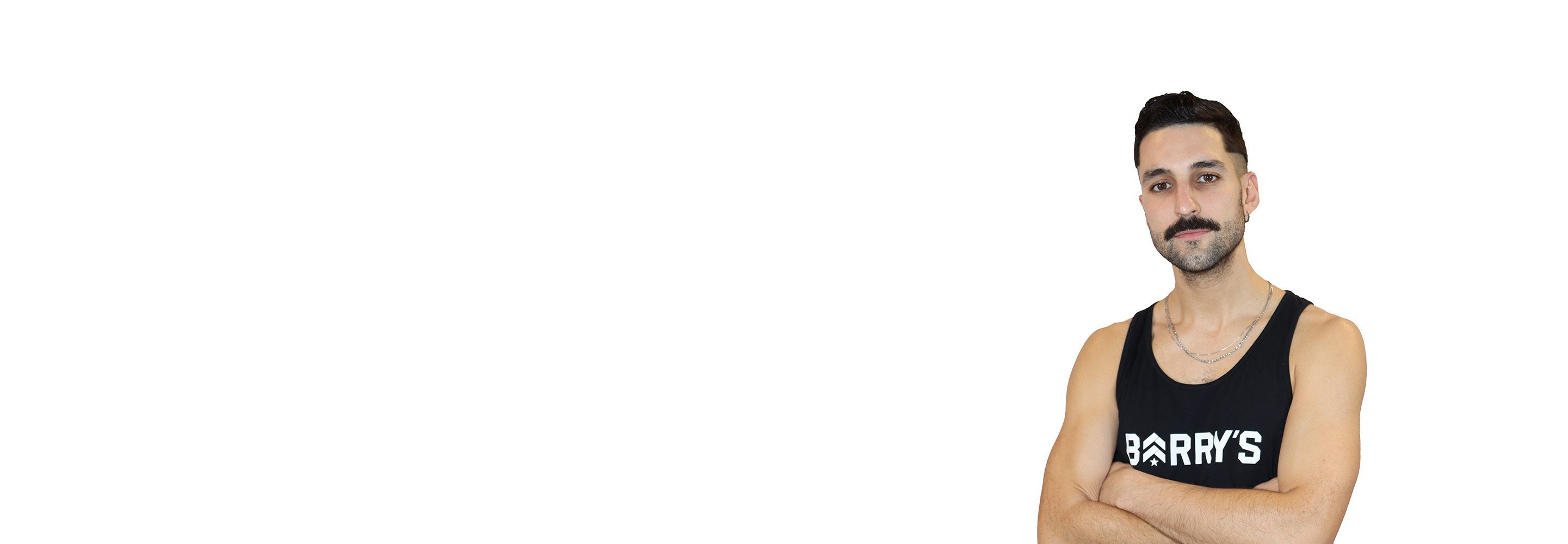Barry’s instructor wearing a black top standing confidently smiling against a white background