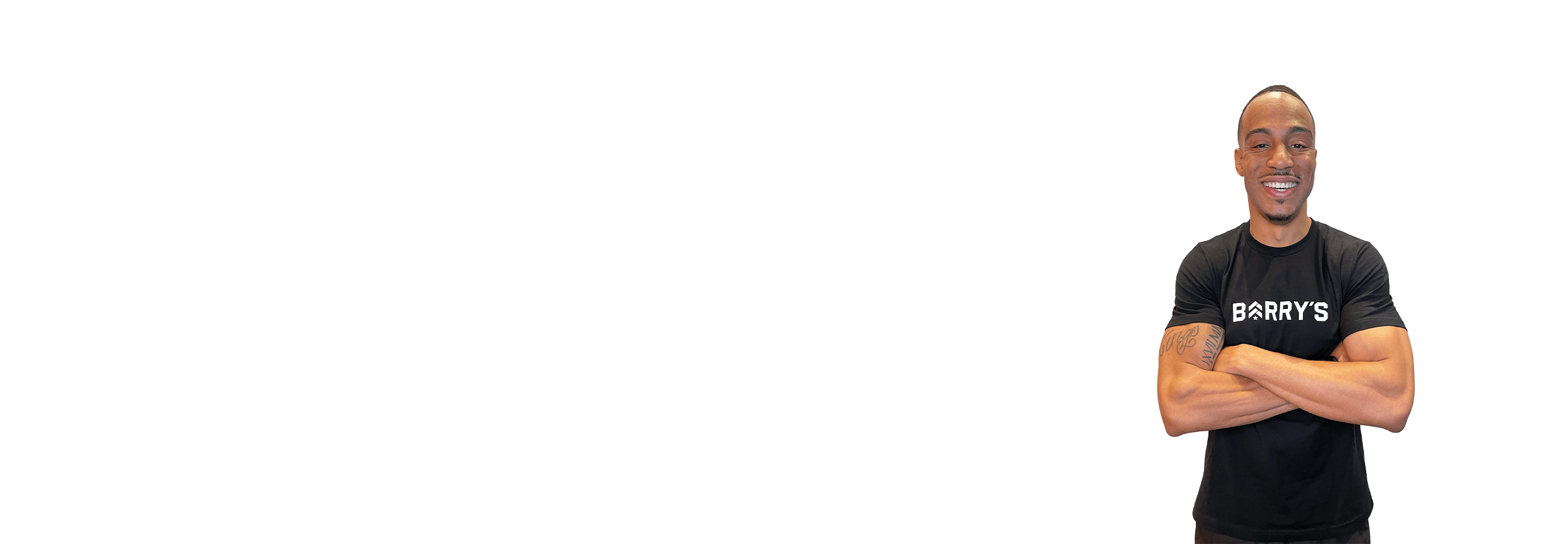 Barry's instructor standing confidently with arms crossed wearing a black top against a white background.