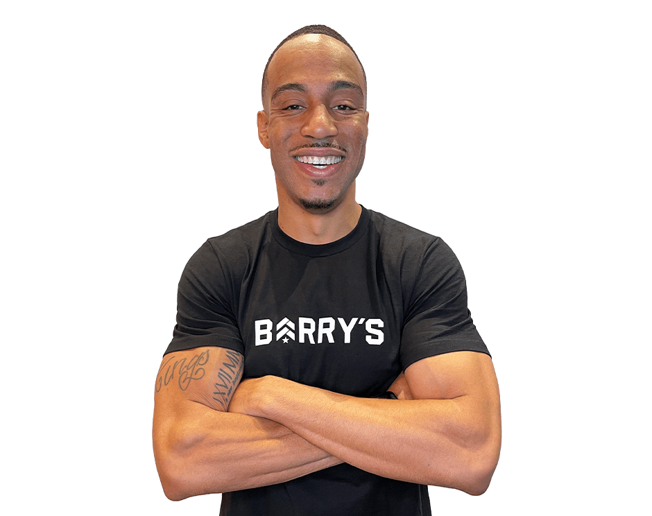 Barry's instructor standing confidently with arms crossed wearing a black top against a white background.