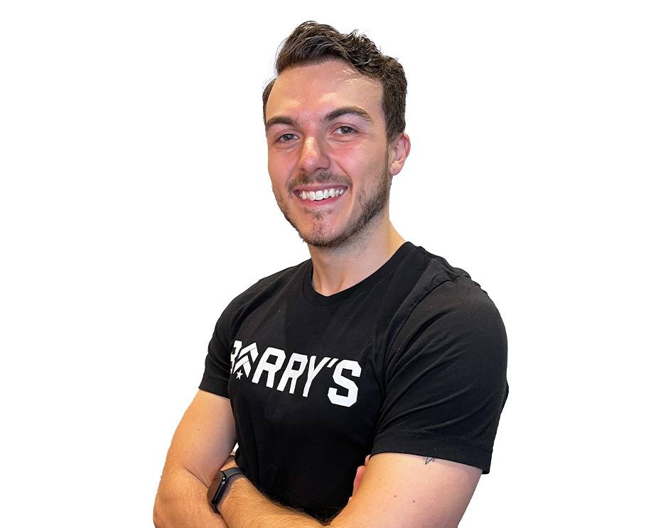 Barry's instructor standing confidently with arms crossed wearing a black top against a white background.