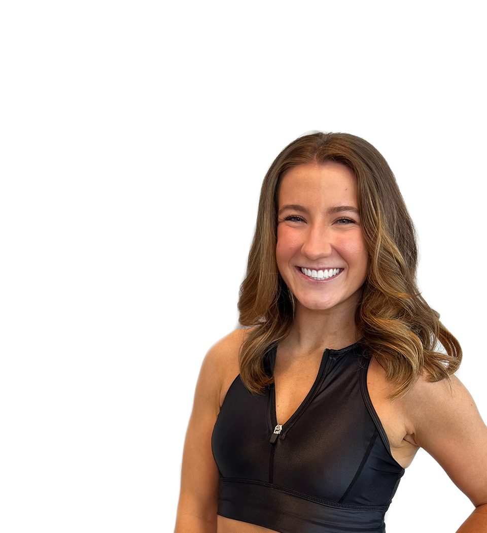 Barry’s instructor wearing a black top standing confidently smiling against a white background