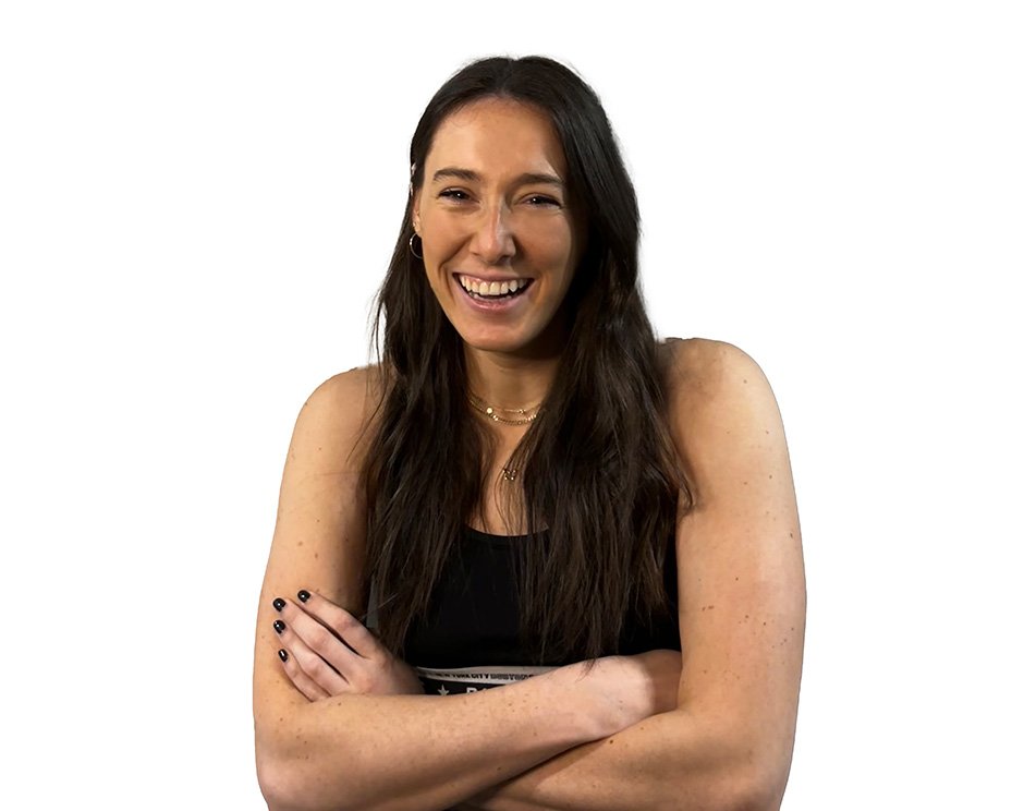 Barry's instructor standing confidently wearing a black tank top against a white background, ready for the next workout challenge.