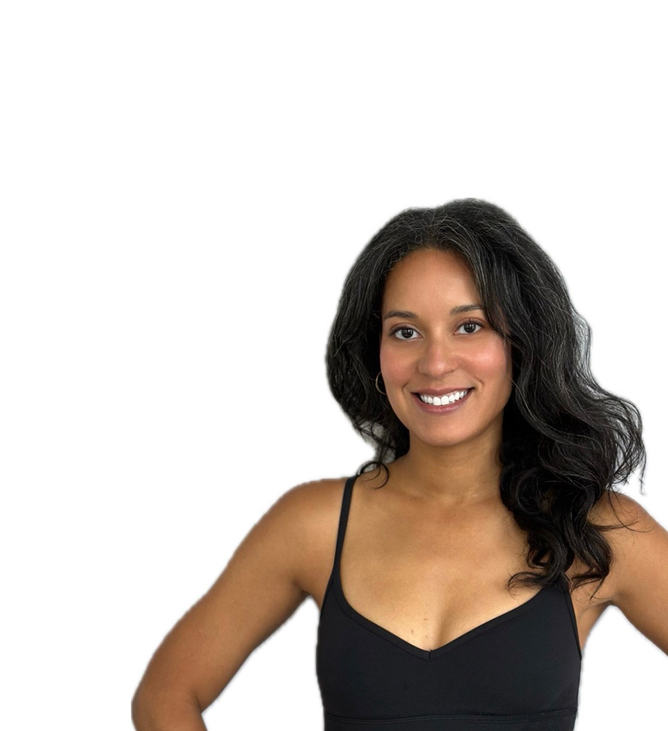 Barry’s instructor wearing a black top standing confidently smiling against a white background