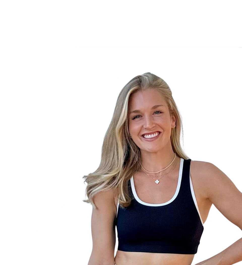 Barry’s instructor wearing a black top standing confidently smiling against a white background